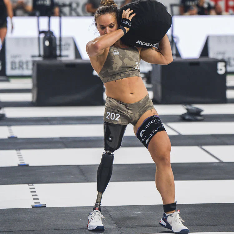 A CrossFit competitor lifting a sandbag as a right above knee amputee.