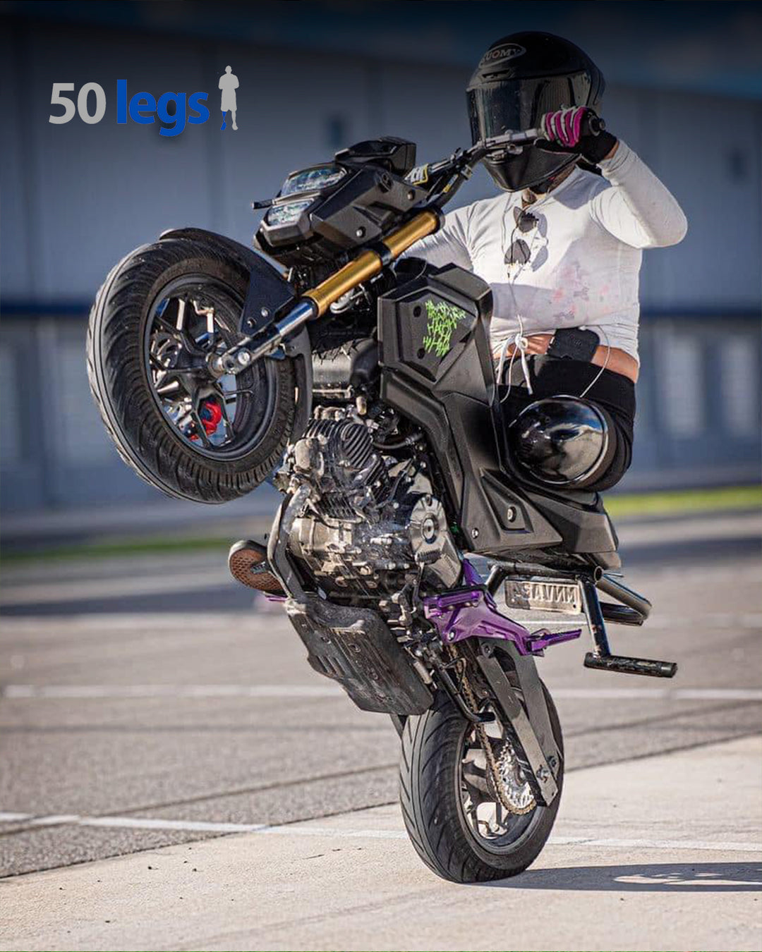 50 Legs recipient performing a wheelie on their motorcycle.