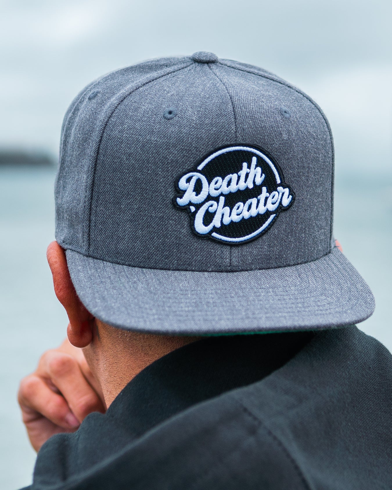 Amplife® Founder Abdul Nevarez wearing the Death Cheater™ Halo Flat Bill Snapback while looking at Alcatraz Island