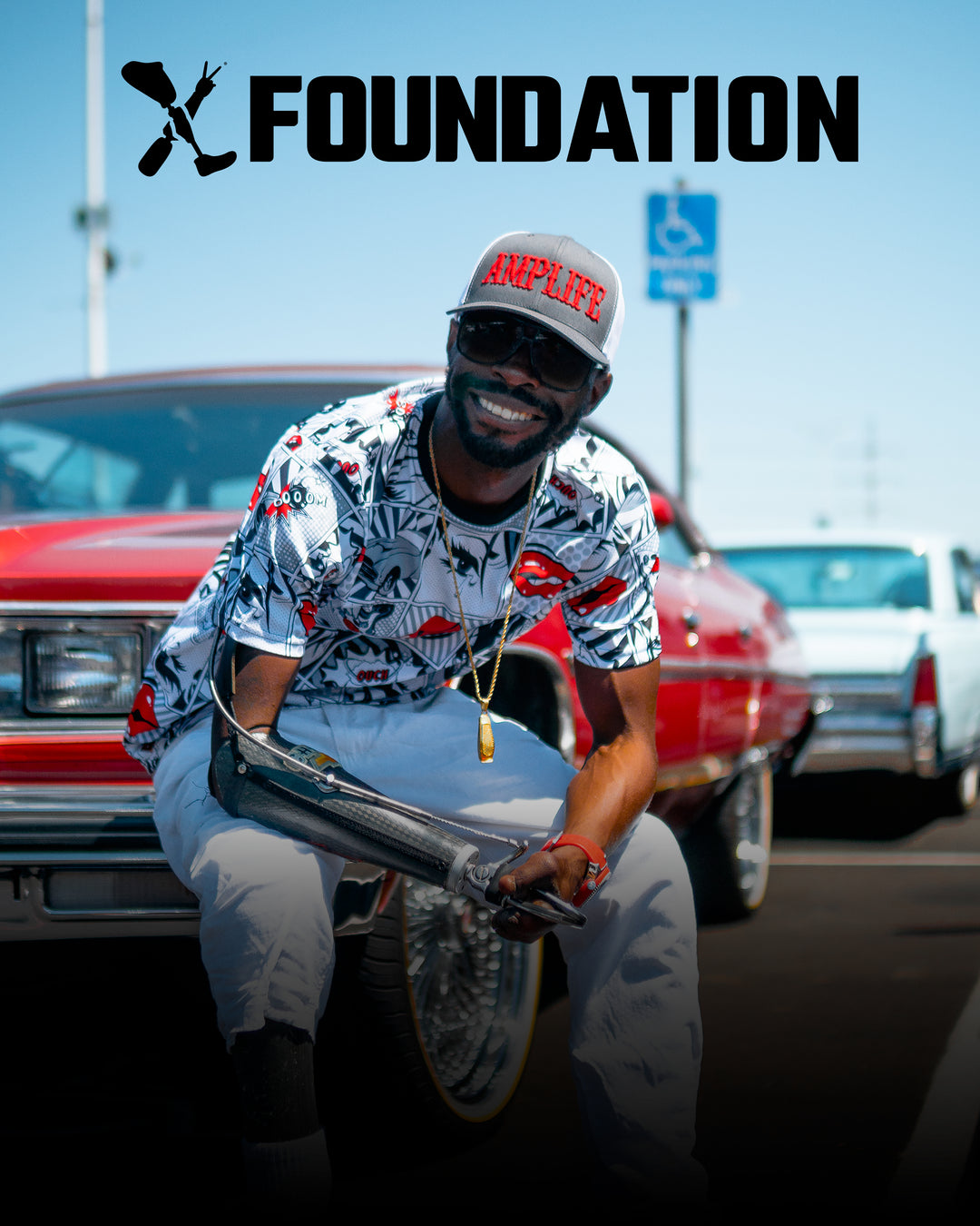 Amplife® supporter smiling and wearing the Amplife® Curved Bill Trucker Snapback sitting on the front bumper of his 1970s Chevy