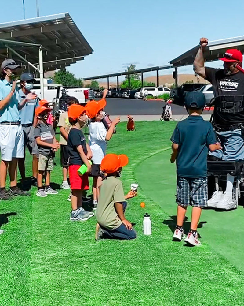 Amplife® Foundation & Amplife® Founder Abdul Nevarez celebrating with a group of kid golfers after he sunk a long putt