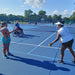 Cincinnati Tennis Foundation beginner adaptive spring tennis participant being served a ball by the coach.