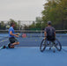 A coach getting ready to serve with a Cincinnati Tennis Foundation advanced wheelchair tennis participant.