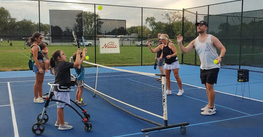 Cincinnati Tennis Foundation Coach with a pickleball participant returning a serve.