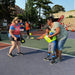 Cincinnati Tennis Foundation Coach with a pickleball participant juggling a ball with the help of their parent.