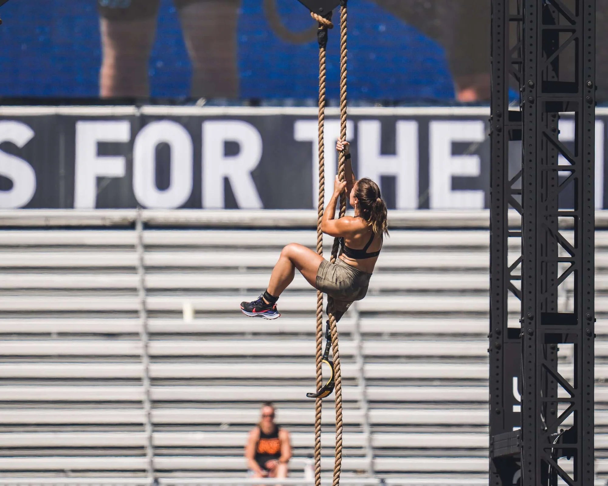 A crossfitter with a leg amputation climbing a rope.