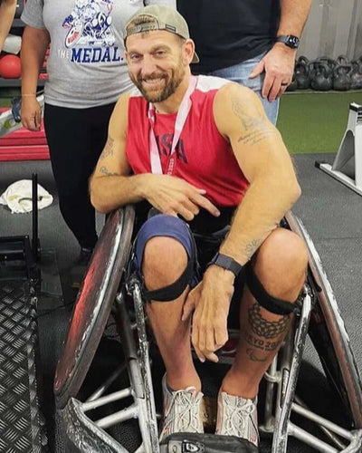 Portrait of Chuck Melton sitting in his wheelchair rugby chair in the gym.