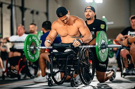 A double above the knee amputee in a competition resting a barbell with 25lbs on each side on the LapMat™.