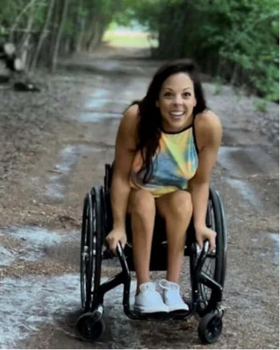 Portrait of Lisa Mozingo in her wheelchair on a dirt path.