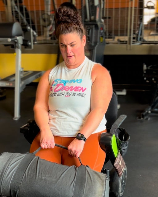 NorCal SCI's Coach Steph Roach lifting a weighted bag in her wheelchair.