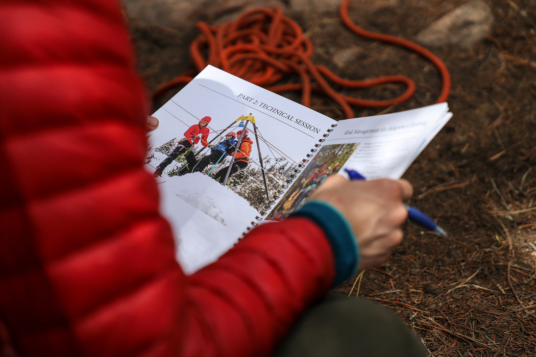 A detail photo of an instructor reading the Paradox Sports Adaptive Climbing Initiative Course.