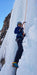 A Paradox Sports climber smiling while ascending the icewall at the Lake City Ice Skills 201.