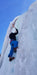 A Paradox Sports climber swinging their ice pick into the icewall at the Lake City Ice Skills 201.