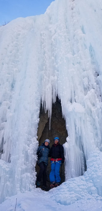 Two Paradox Sports climbers smiling while standing inside a hole of an icewall at the Lake City Ice Skills 201.